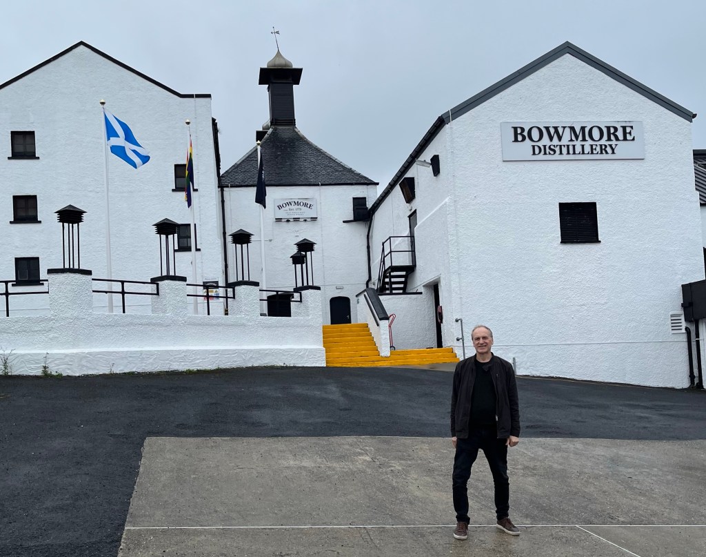 Bowmore distillery, Islay, Scotland: man and Scottish flag